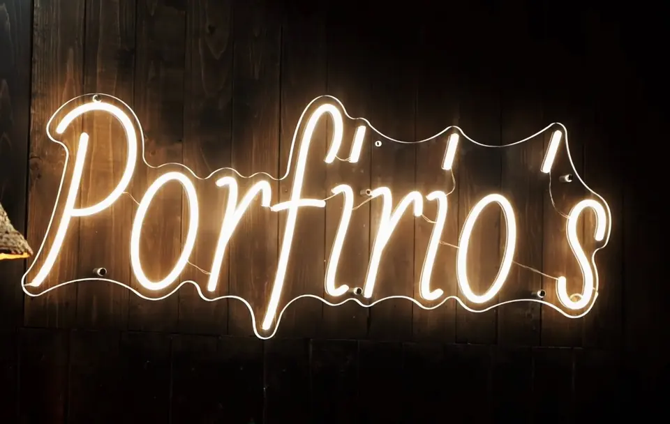 The neon Porfirio's sign on the wood wall